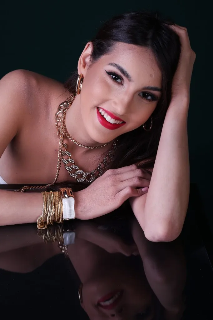 Model smiling, hand in her hair, gold jewelry