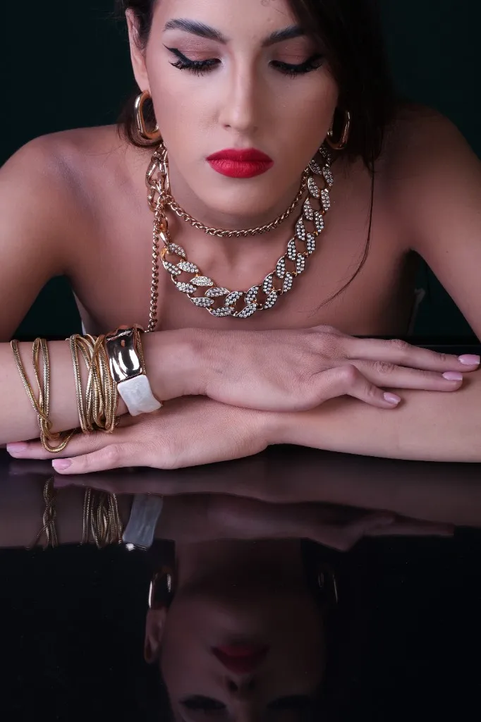 Close portrait, gaze to camera, diamond and gold necklaces