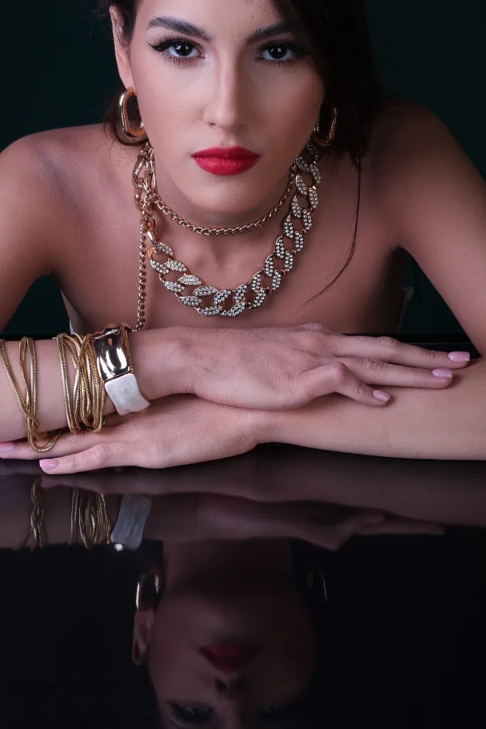Model gazing to camera, hands resting on the mirror