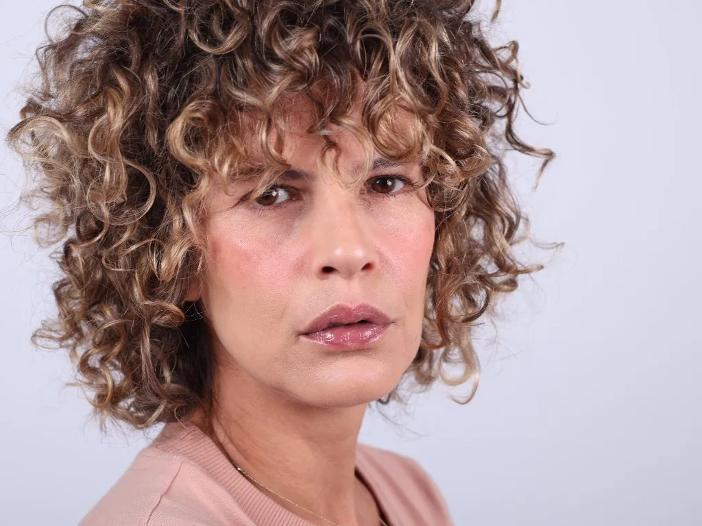 Woman turned three-quarters, a direct and serious gaze over the shoulder