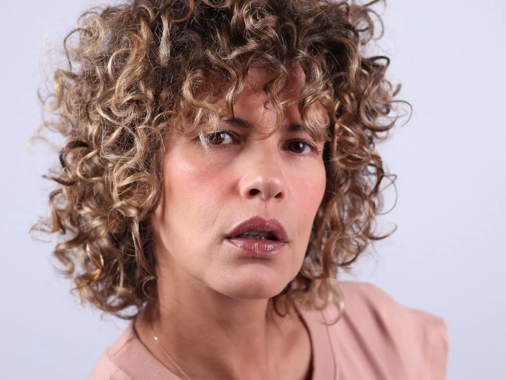 Close portrait, lips parted mid-word, an urgent expression