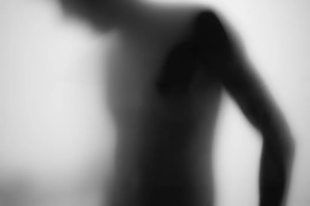 The side of a torso and arm in soft silhouette